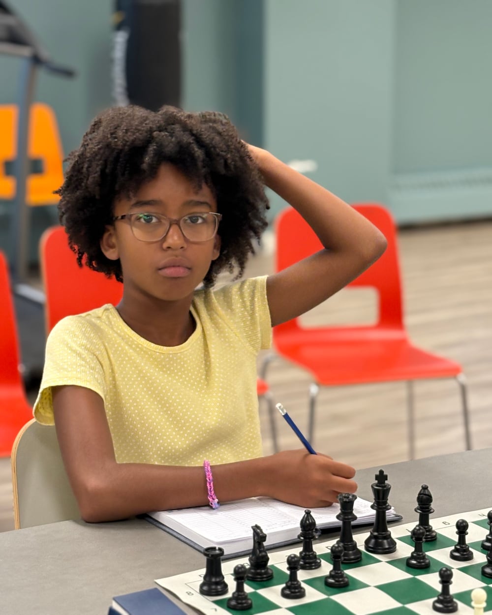 Young participant writing down her analysis during a game